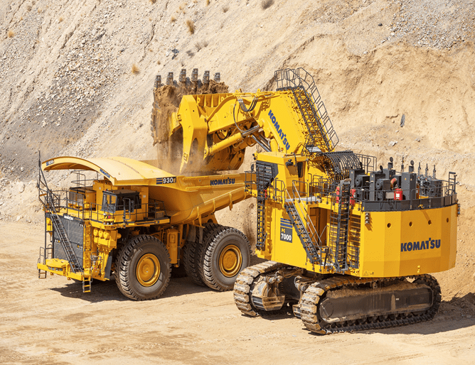 A large yellow dump truck and a big yellow tractor.