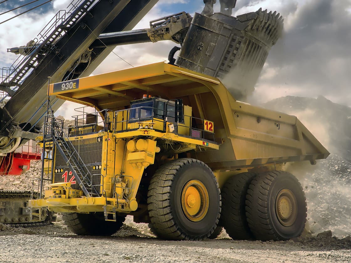 A large yellow dump truck with a crane on top.