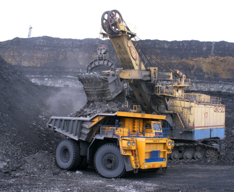 A dump truck is loaded with coal at the open pit.